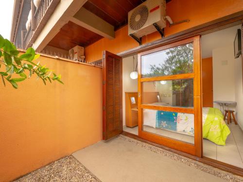 an orange room with a door and a window at Pousada Pé Na Areia in Caraguatatuba