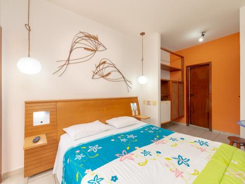 a bedroom with a large bed with a blue comforter at Pousada Pé Na Areia in Caraguatatuba