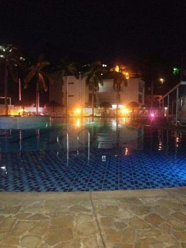 a swimming pool at night with lights at Apartasol Santa Fe Oficial in Santa Fe de Antioquia