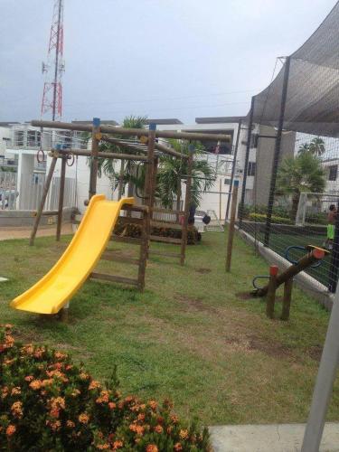 a playground with a yellow slide in a park at Apartasol Santa Fe Oficial in Santa Fe de Antioquia