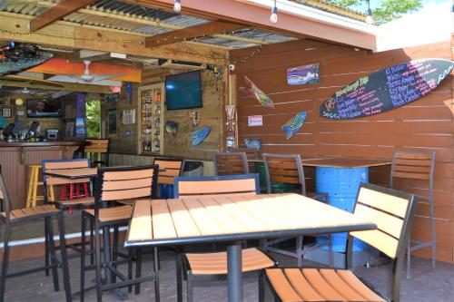 a restaurant with tables and chairs and a surfboard on the wall at Casa Verde Hotel - Steps to the Beach, Pool, Restaurant & Bar in Rincon