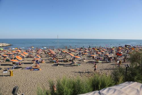 a large crowd of people on a beach with umbrellas at Village Camping Joker in Cavallino-Treporti
