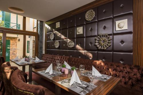 a dining room with two tables and a booth at Duna Garden Hotel in Budapest