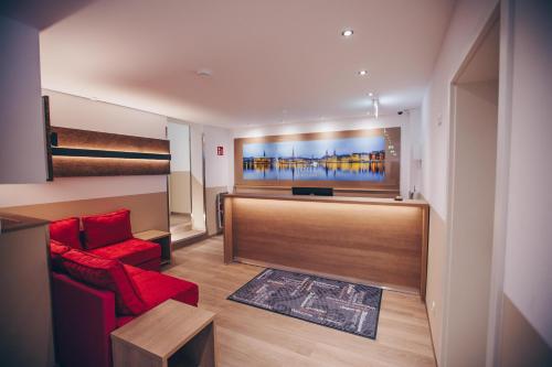 a living room with a red couch and a flat screen tv at Hotel Luckys Inn in Hamburg