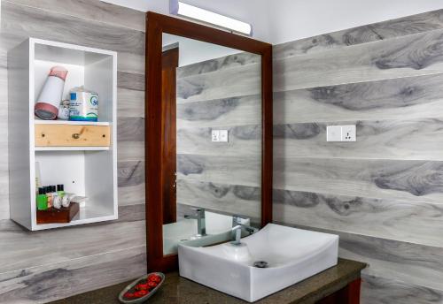 a bathroom with a sink and a mirror at Hotel Bella Vista in Anuradhapura