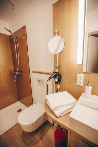 a bathroom with a toilet and a sink and a mirror at Hotel Luckys Inn in Hamburg