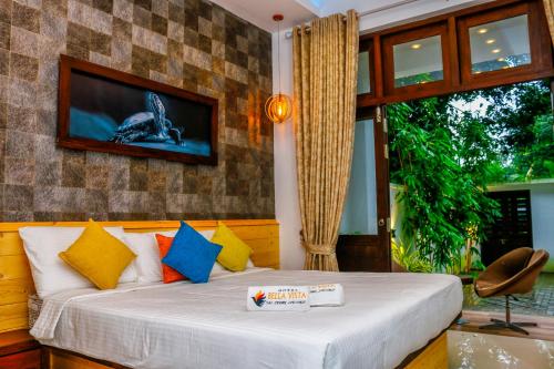a bedroom with a bed with a tv on the wall at Hotel Bella Vista in Anuradhapura
