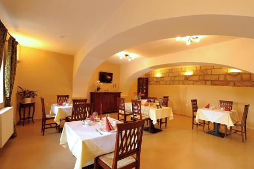 a dining room with white tables and chairs at Hotel U Krále in Jičín