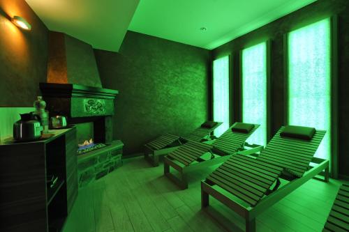 a green room with chairs and a fireplace at Hotel Bertusi in Porretta Terme