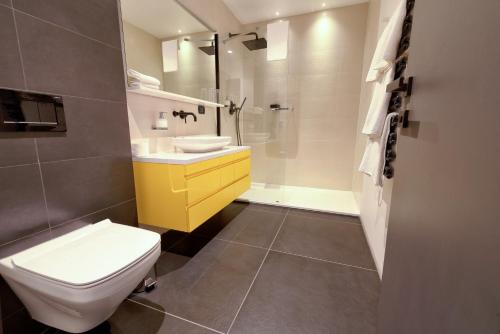 a bathroom with a toilet and a sink and a shower at Donautica Hotel & Restaurant in Fadd-Dombori