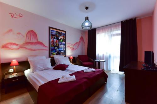 a hotel room with a large bed and a window at Hotel Ida in Bansko