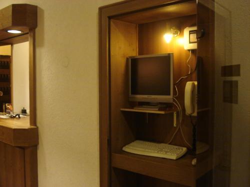 a computer on a shelf with a keyboard and a phone at Regerhof in Germering