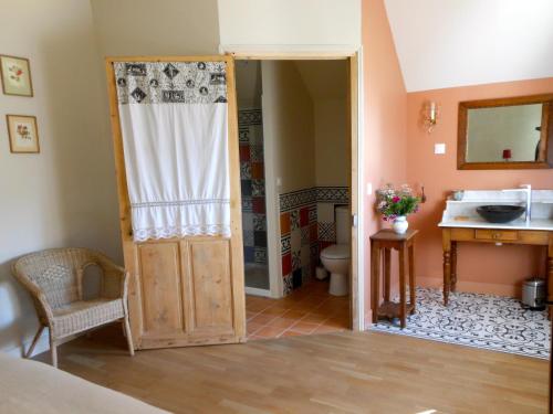 une salle de bain avec un lavabo et des toilettes et une porte dans l'établissement Auberge de la Tuilerie, à Andryes