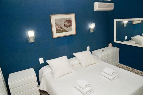 ポルト・ダ・ポリェンサにあるVoramar on Pinewalkの青いベッドルーム(白いベッド1台、鏡付)