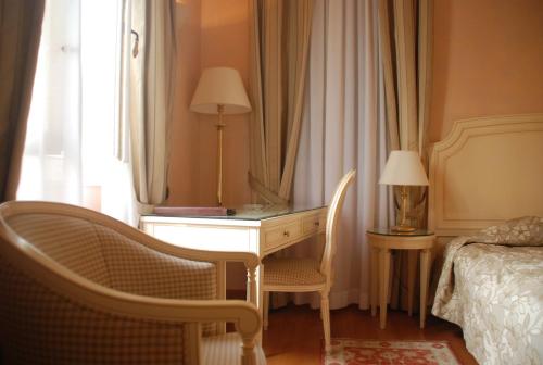 a bedroom with a desk and a bed and a window at Siora Vittoria Boutique Hotel in Corfu Town