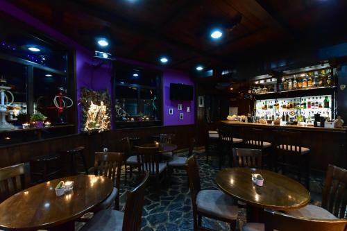 a restaurant with wooden tables and chairs and a bar at Hotel Ida in Bansko