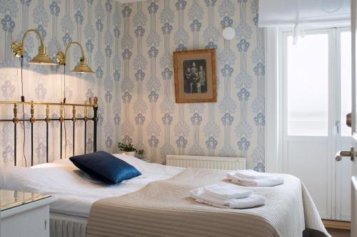 1 dormitorio con 1 cama con toallas en Strandvillan Hotell och Bed & Breakfast, en Lysekil