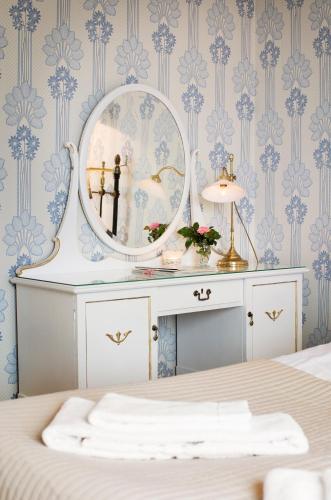 a bedroom with blue and white wallpaper and a mirror at Strandvillan Hotell och Bed & Breakfast in Lysekil