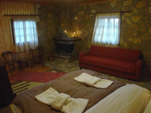 1 dormitorio con 1 cama y 1 sofá rojo en Φάρμα της φονισσας en Réthion