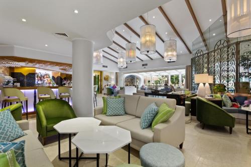 a lobby with a couch and chairs and a bar at Four Seasons Country Club in Quinta do Lago