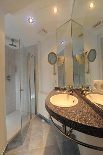 a bathroom with two sinks and a shower at Hotel Heldt in Bremen