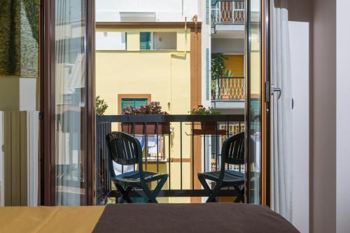 Habitación con 2 sillas y balcón. en KiBari B&B en Bari