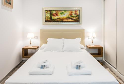 マドリードにあるPUERTA DEL SOL CITY CENTER IV Cのベッドルーム(白い大型ベッド、ランプ2つ付)