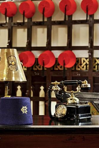 a table with an old phone and a gold bell at Sofitel Legend Old Cataract in Aswan