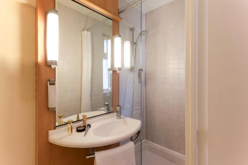 a bathroom with a sink and a shower at Ibis Pau Centre in Pau