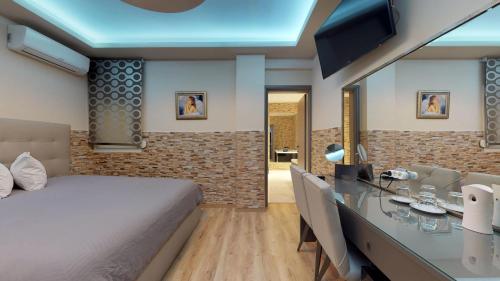 sypialnia z łóżkiem i biurkiem z telewizorem w obiekcie Luxury Living Apartments and Spa w Salonikach