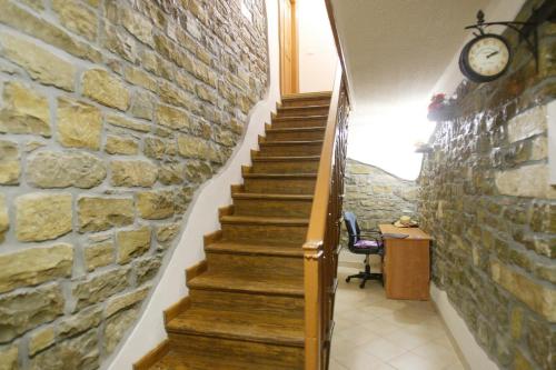 a staircase with a stone wall and a clock on a wall at Rooms Sara in Grožnjan