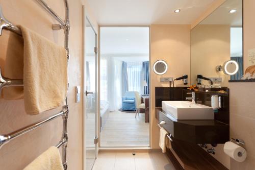 ein Badezimmer mit Waschbecken und Spiegel in der Unterkunft Strandhotel Georgshöhe in Norderney