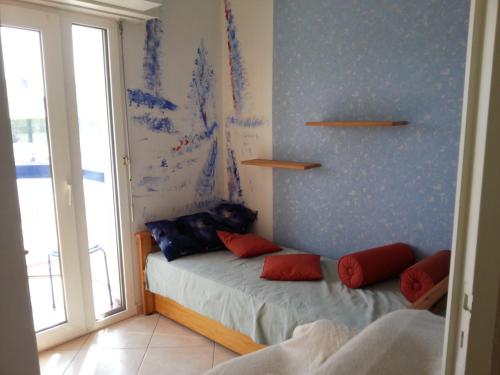 - une chambre avec un lit doté d'oreillers rouges dans l'établissement Charme et Océan face à la plage, à Plougonvelin