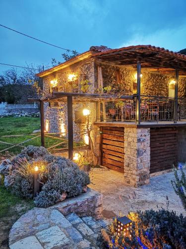 a stone house with a deck with lights on it at Green's House in Poliána