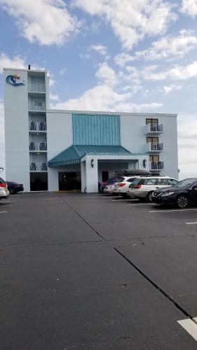a building with cars parked in a parking lot at Beachside Hotel - POOL IS OPEN! in Daytona Beach