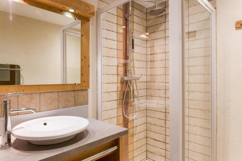 La salle de bains est pourvue d'un lavabo et d'une douche. dans l'établissement Chalet-Hôtel Le Beausoleil, The Originals Relais (Hotel-Chalet de Tradition), à La Toussuire