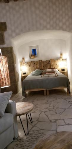 a bedroom with a bed and a chair and a couch at Bocage Belle Histoire in Moutiers-sous-Chantemerle