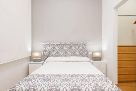 een witte slaapkamer met een groot bed en 2 lampen bij Canadian 1 in Córdoba