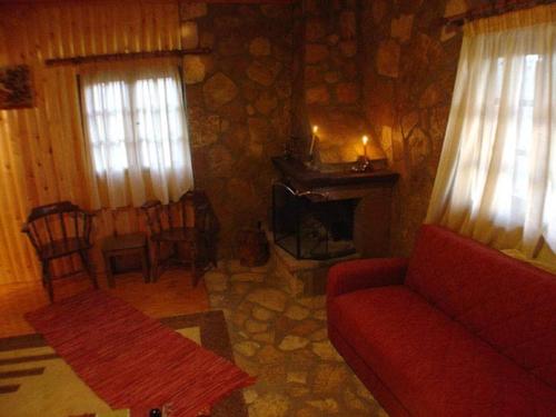 sala de estar con sofá rojo y chimenea en Φάρμα της φονισσας en Réthion