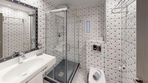 a bathroom with a shower and a sink and a mirror at Luxury Living Apartments and Spa in Thessaloniki