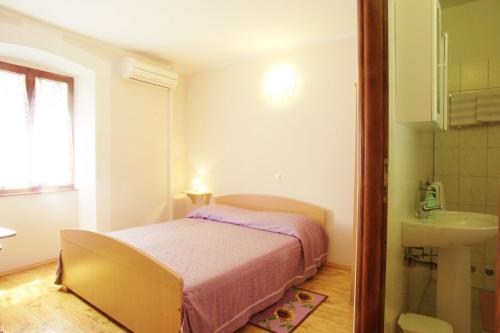 ein kleines Schlafzimmer mit einem Bett und einem Waschbecken in der Unterkunft Rooms Sara in Grožnjan