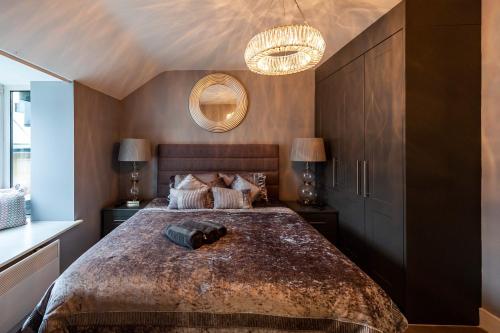 Un dormitorio con una cama grande y una lámpara de araña. en The Town House,Kinsale,in town centre, Exquisite holiday homes, sleeps 16 en Kinsale