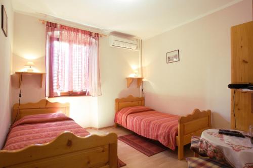 1 dormitorio con 2 camas y ventana en Rooms Sara, en Grožnjan