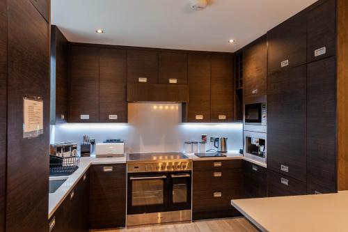a large kitchen with wooden cabinets and appliances at The Town House Kinsale, Hosted by Exquisite holiday homes, sleeps 16 in Kinsale