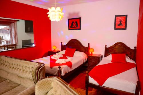 a red bedroom with two beds and a couch at SEIA Alojamentos Leitao in Seia