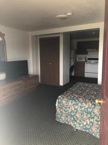 Marshfield的住宿－Neva Jean Motel，配有一张床和一台平面电视的酒店客房