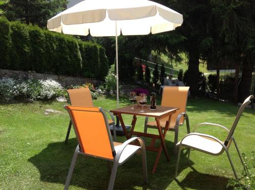 a table and chairs under an umbrella in a yard at Chalet Heimetli in Grächen