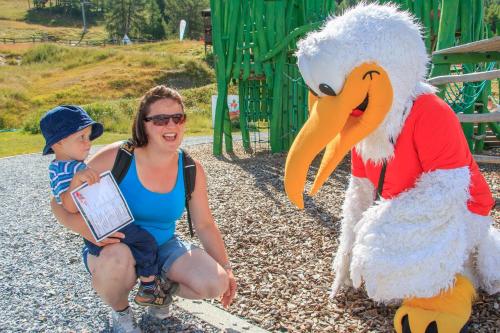 a woman holding a child sitting next to a stuffed chicken at Chalet Heimetli in Grächen