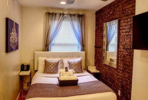 een slaapkamer met een bed met een bakstenen muur bij Chelsea Inn in New York