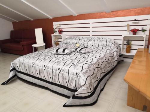 um quarto com uma cama grande e um sofá vermelho em B&b La Camelia em Santeramo in Colle